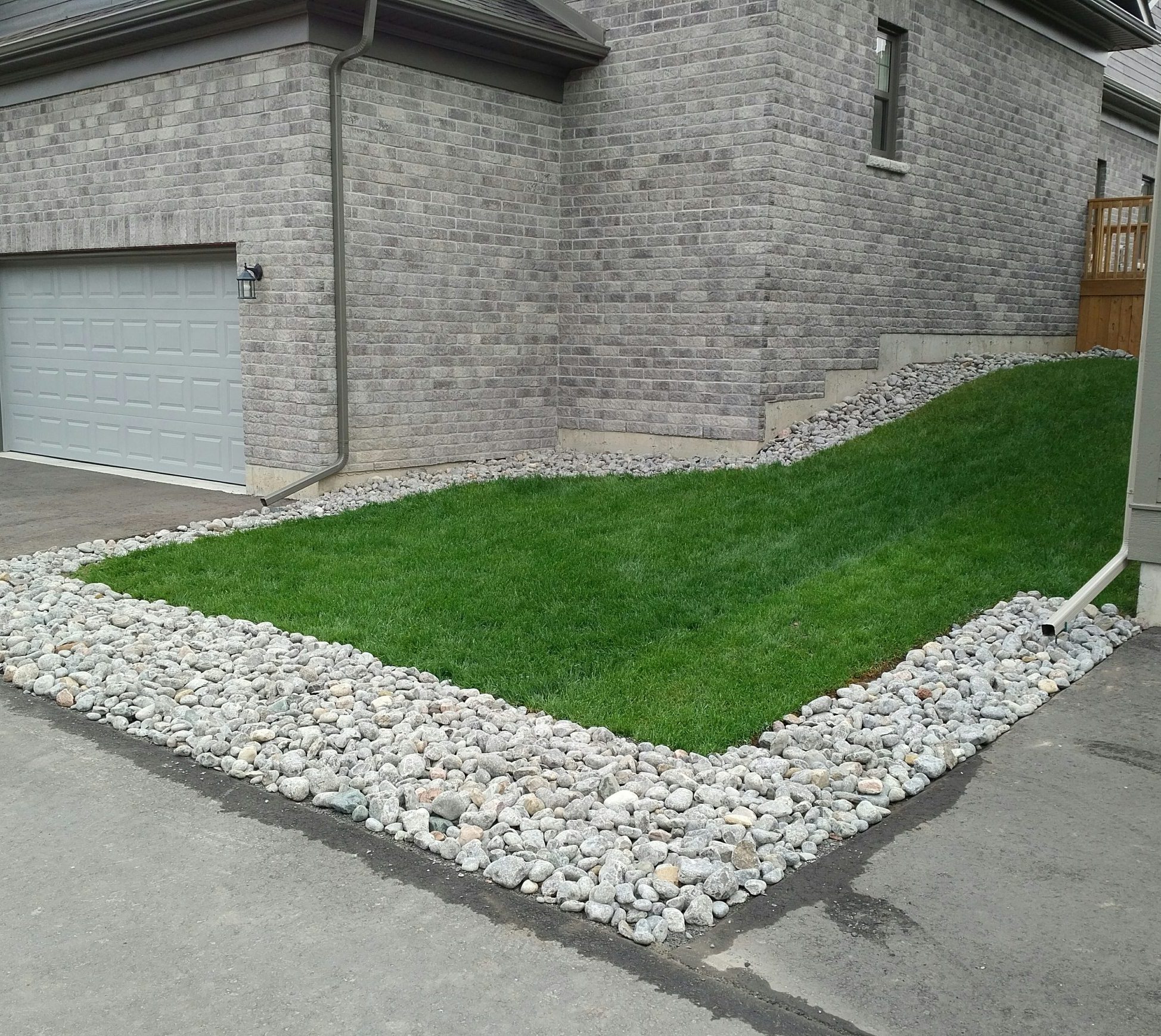 Garage with landscaped grass and stone border