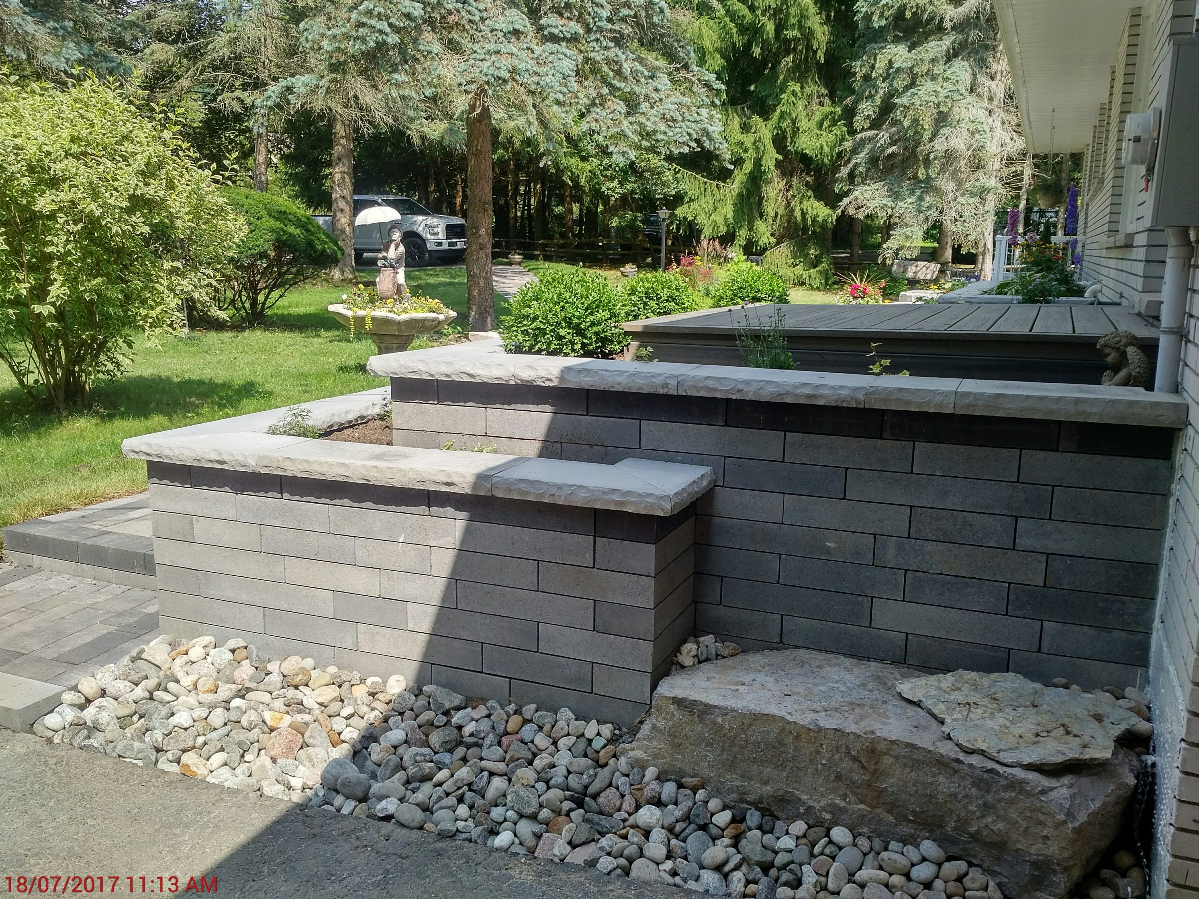 Outdoor patio with stone wall and garden view