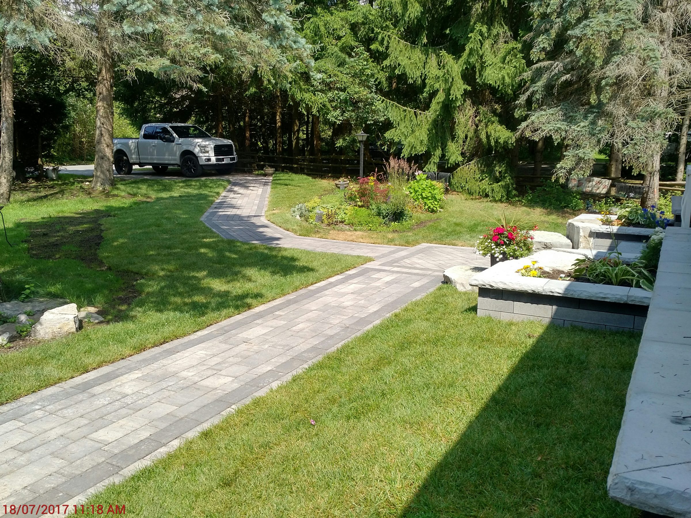 Modern garden with pathway and parked truck