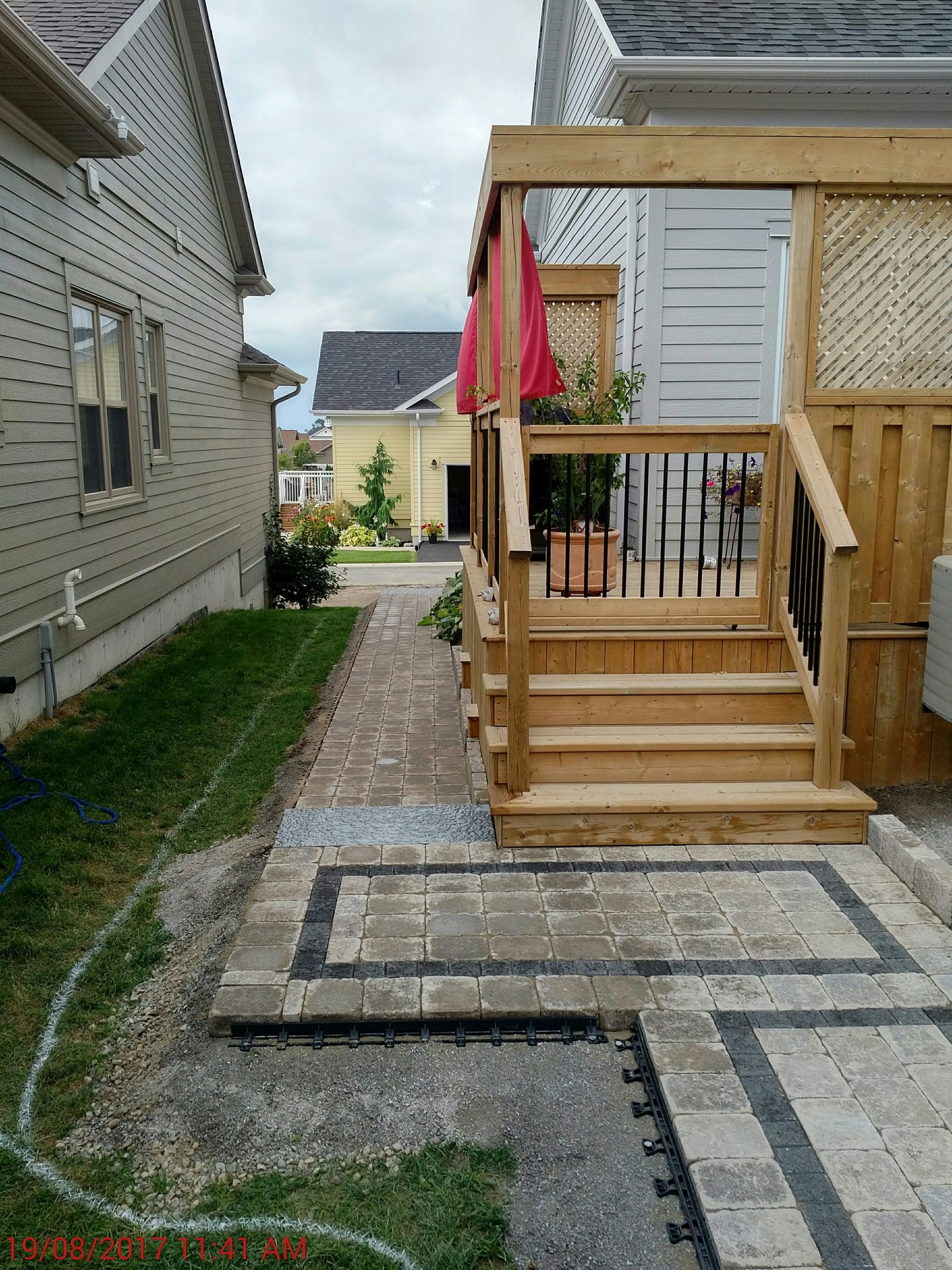 Backyard with deck and stone pathway between houses.