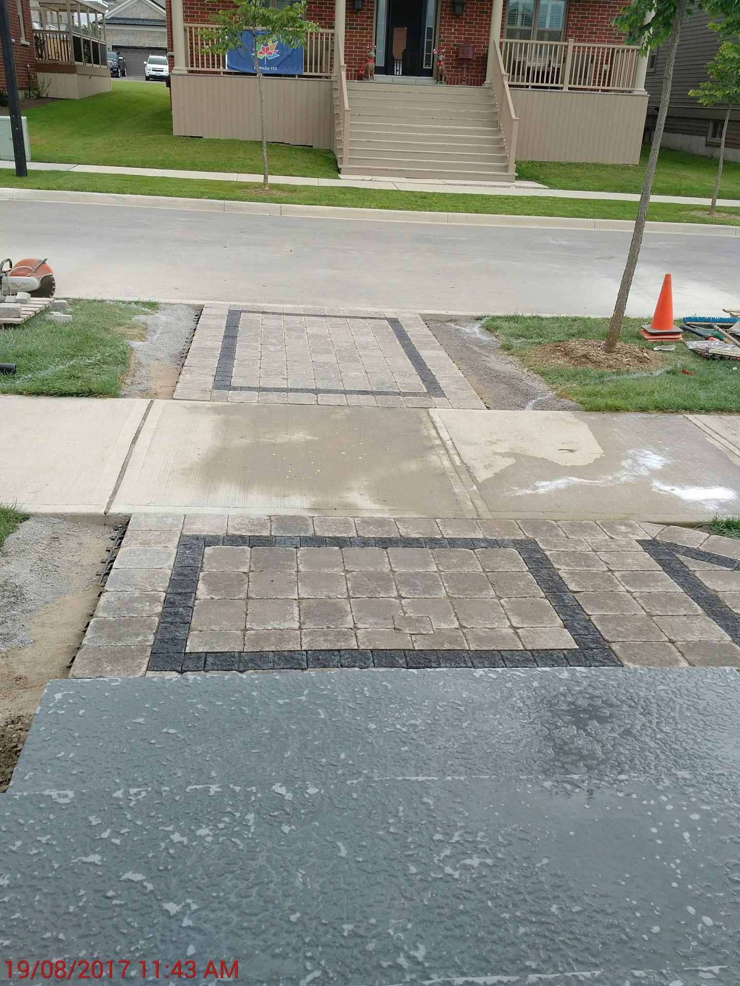 Newly paved driveway with construction materials nearby.