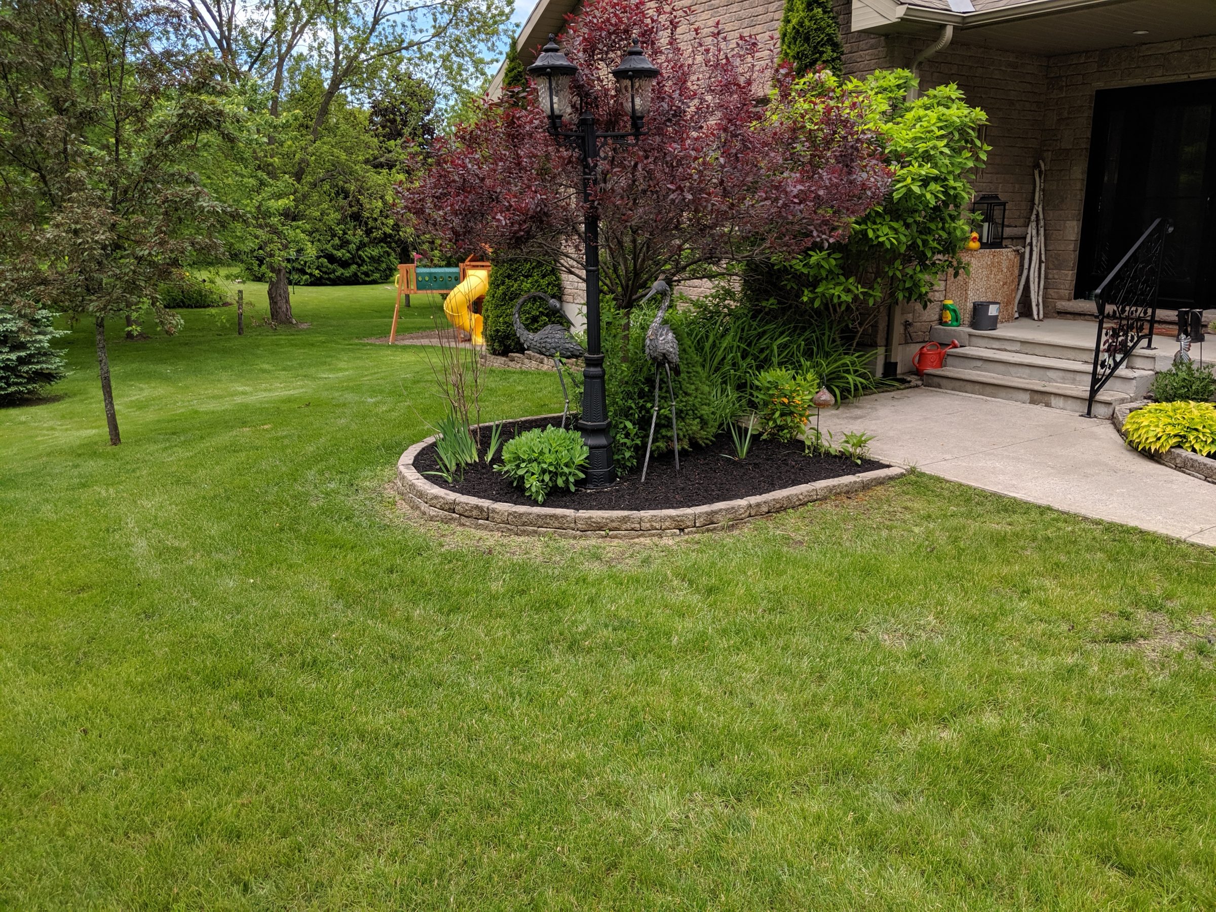 Green lawn with trees and porch decorations.