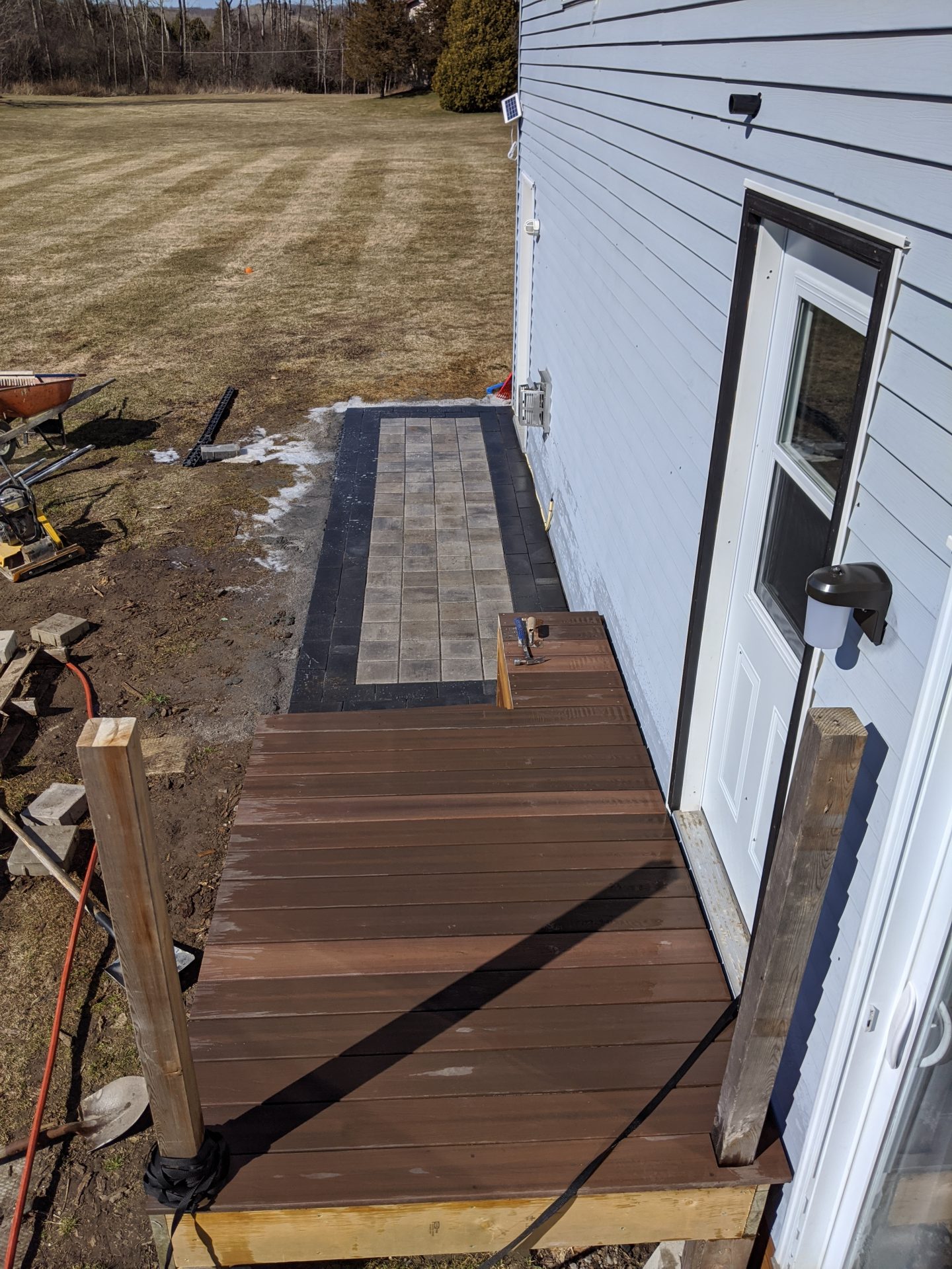 Wooden and tiled patio construction outside house.