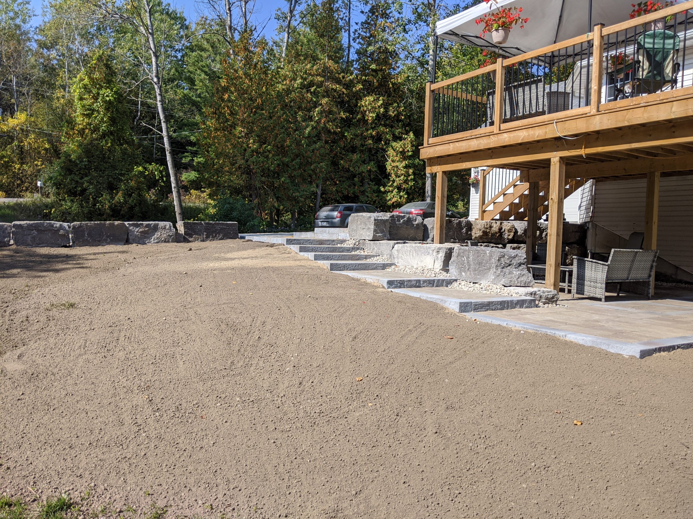 Backyard construction with stone steps and wooden deck.