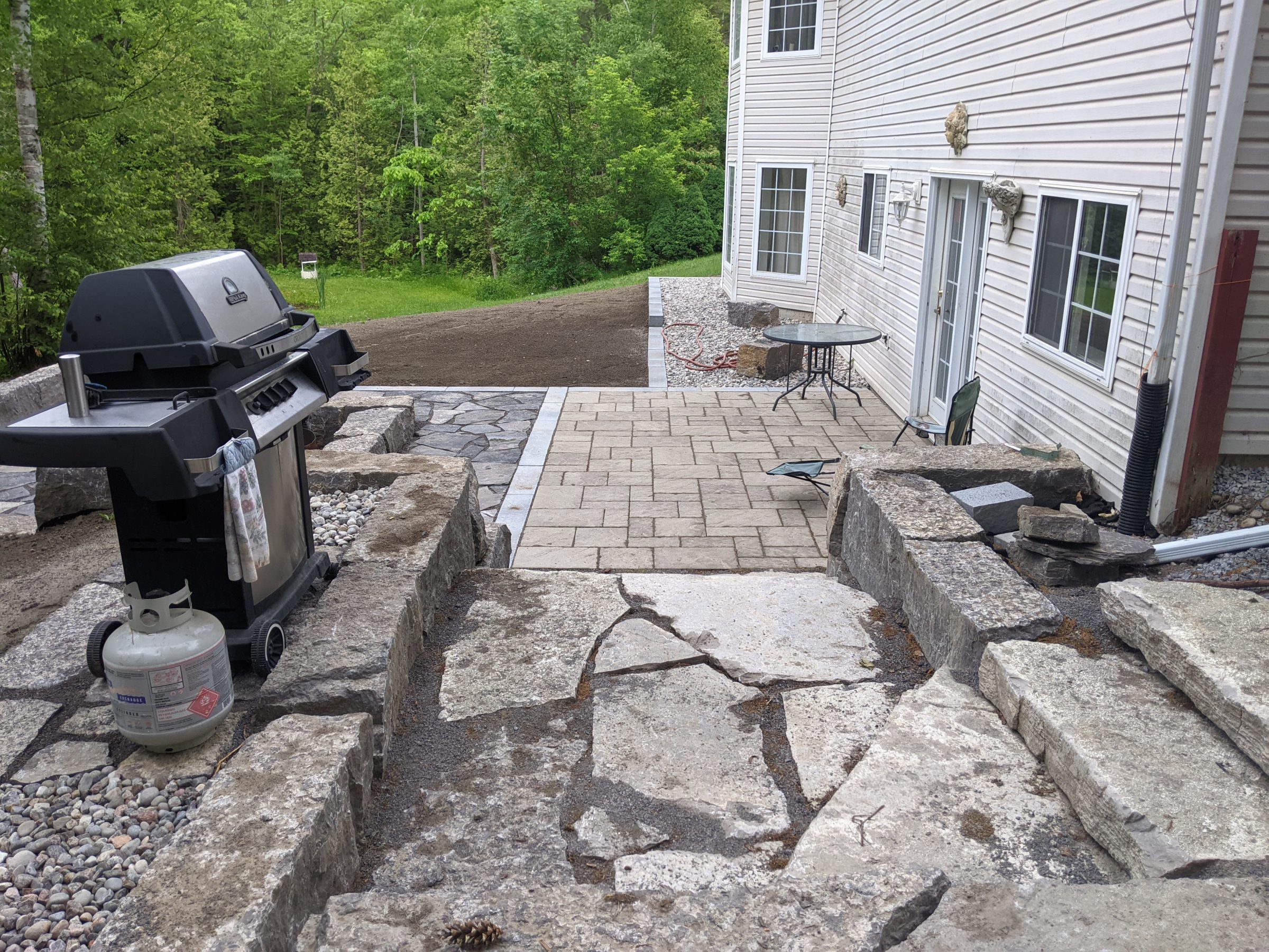 Backyard patio with grill and stone pathway