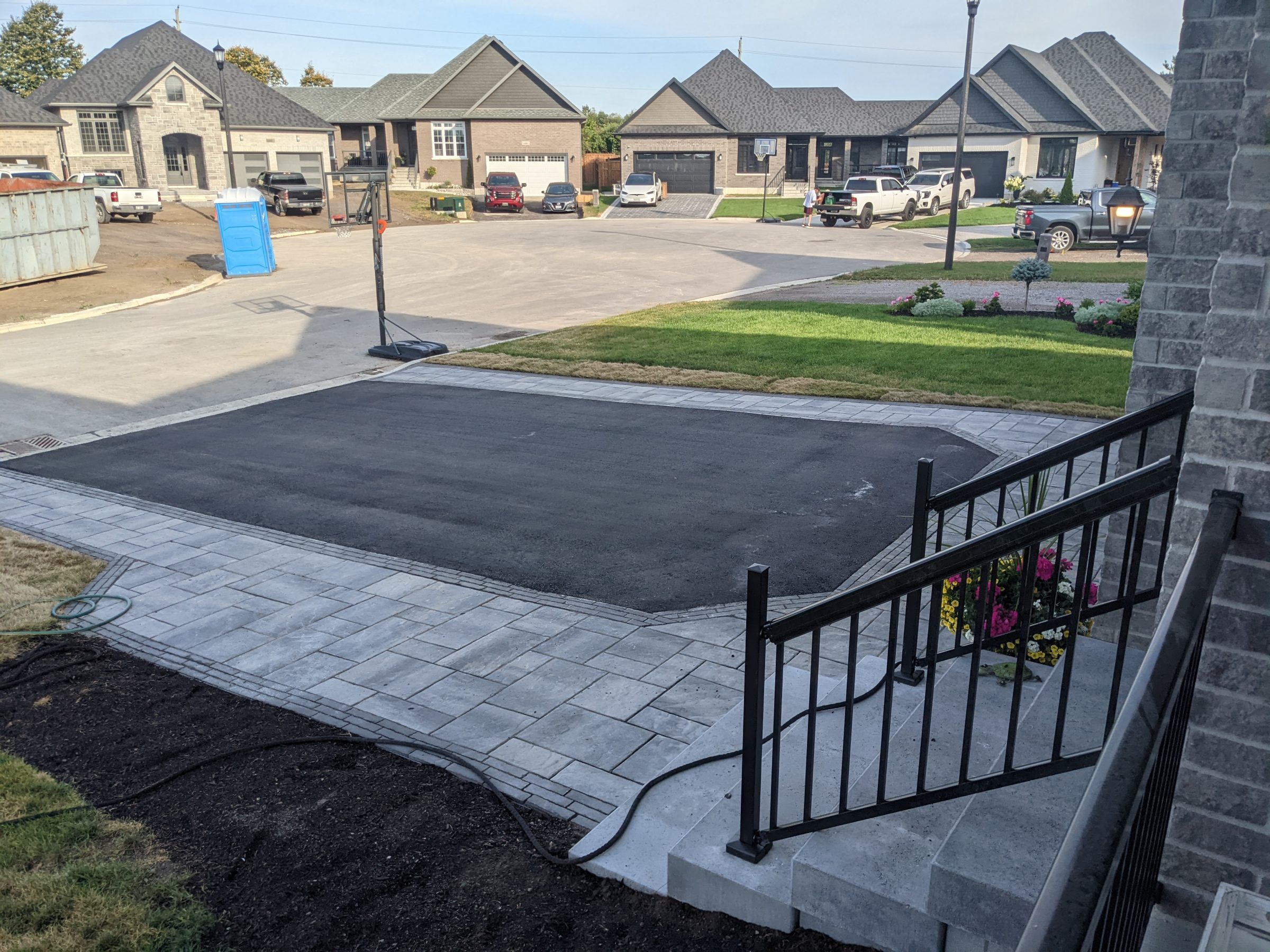 Residential neighborhood with new paved driveway and gardens.