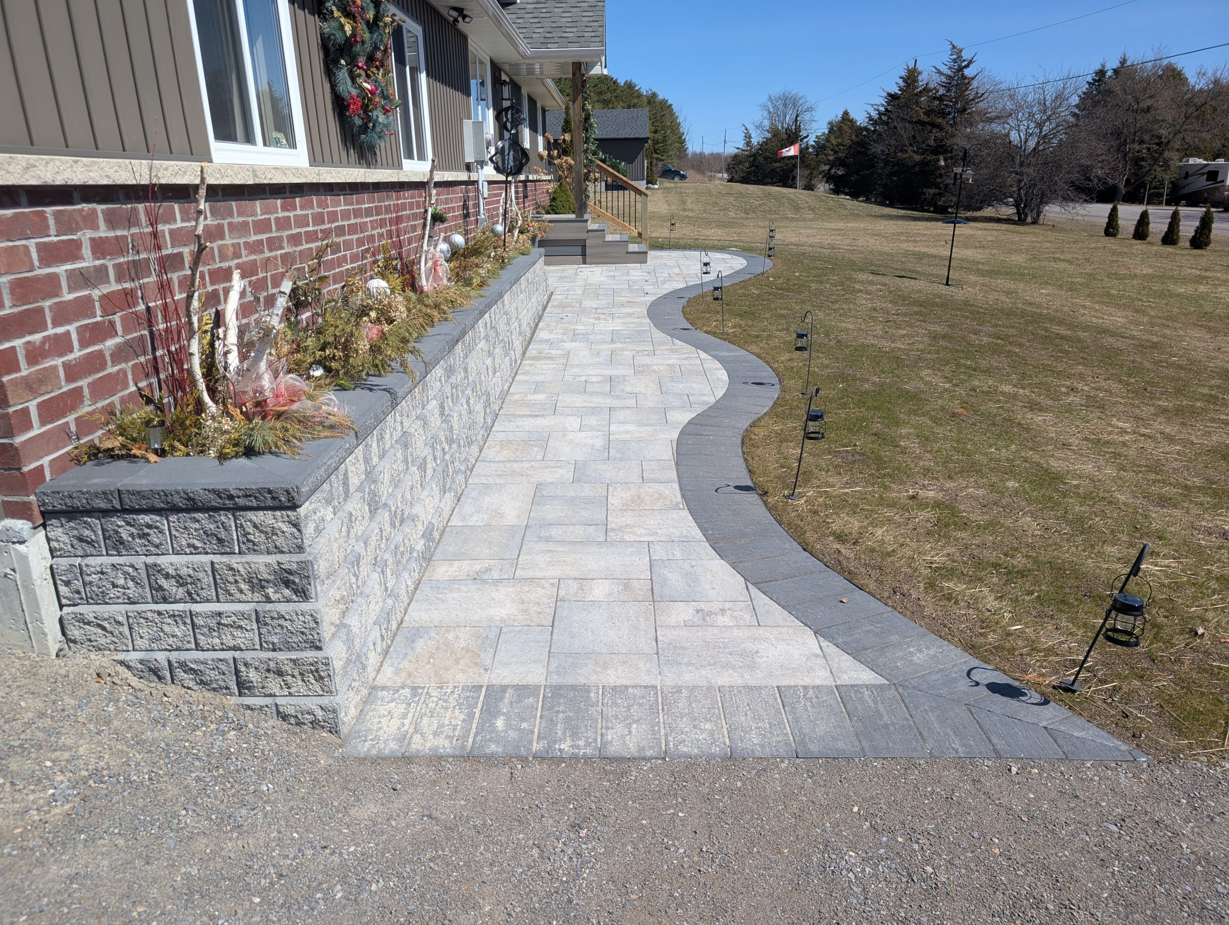 Brick pathway with decorative planters and grass lawn.
