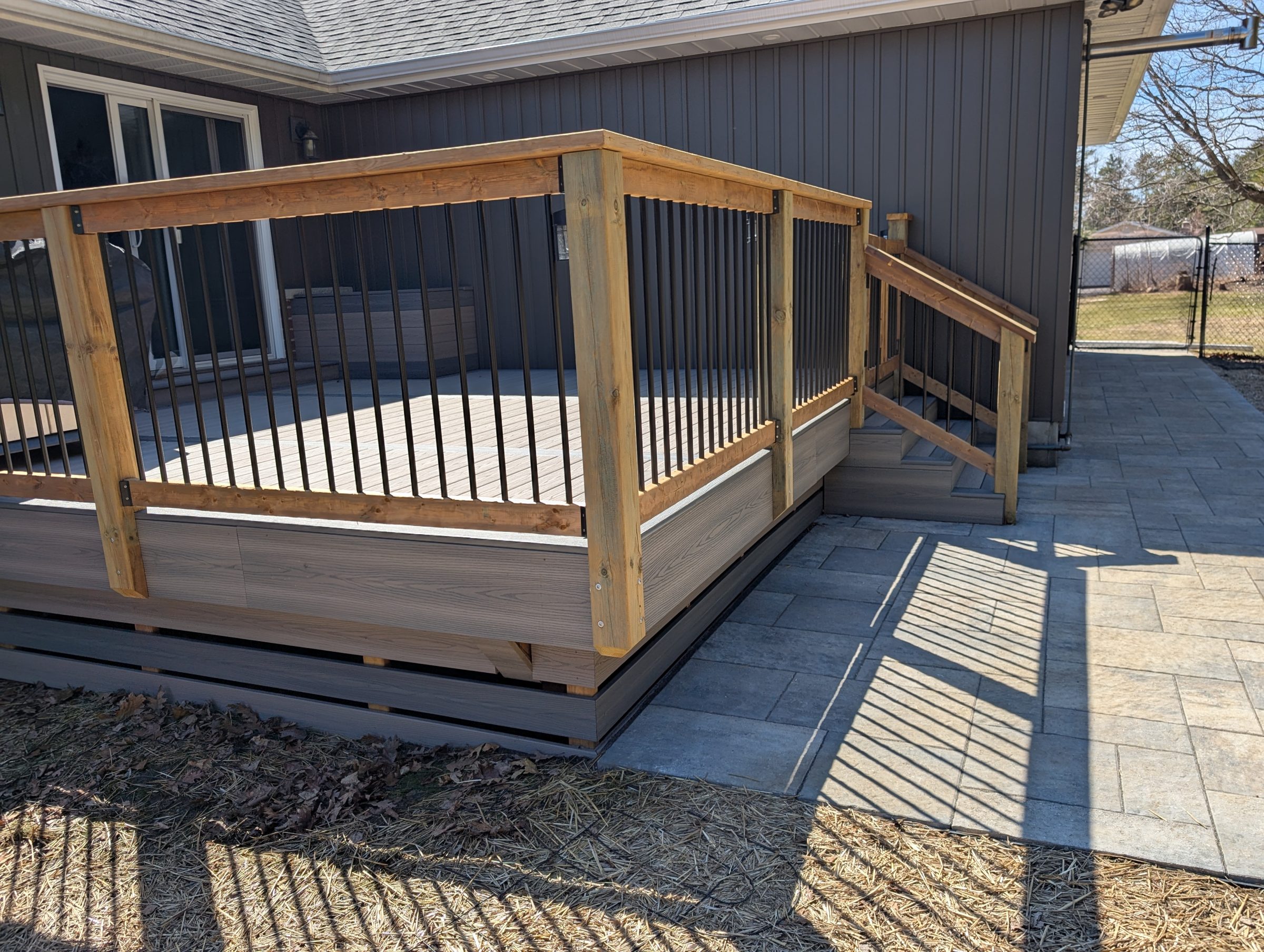 Wooden deck with stairs and patio area.