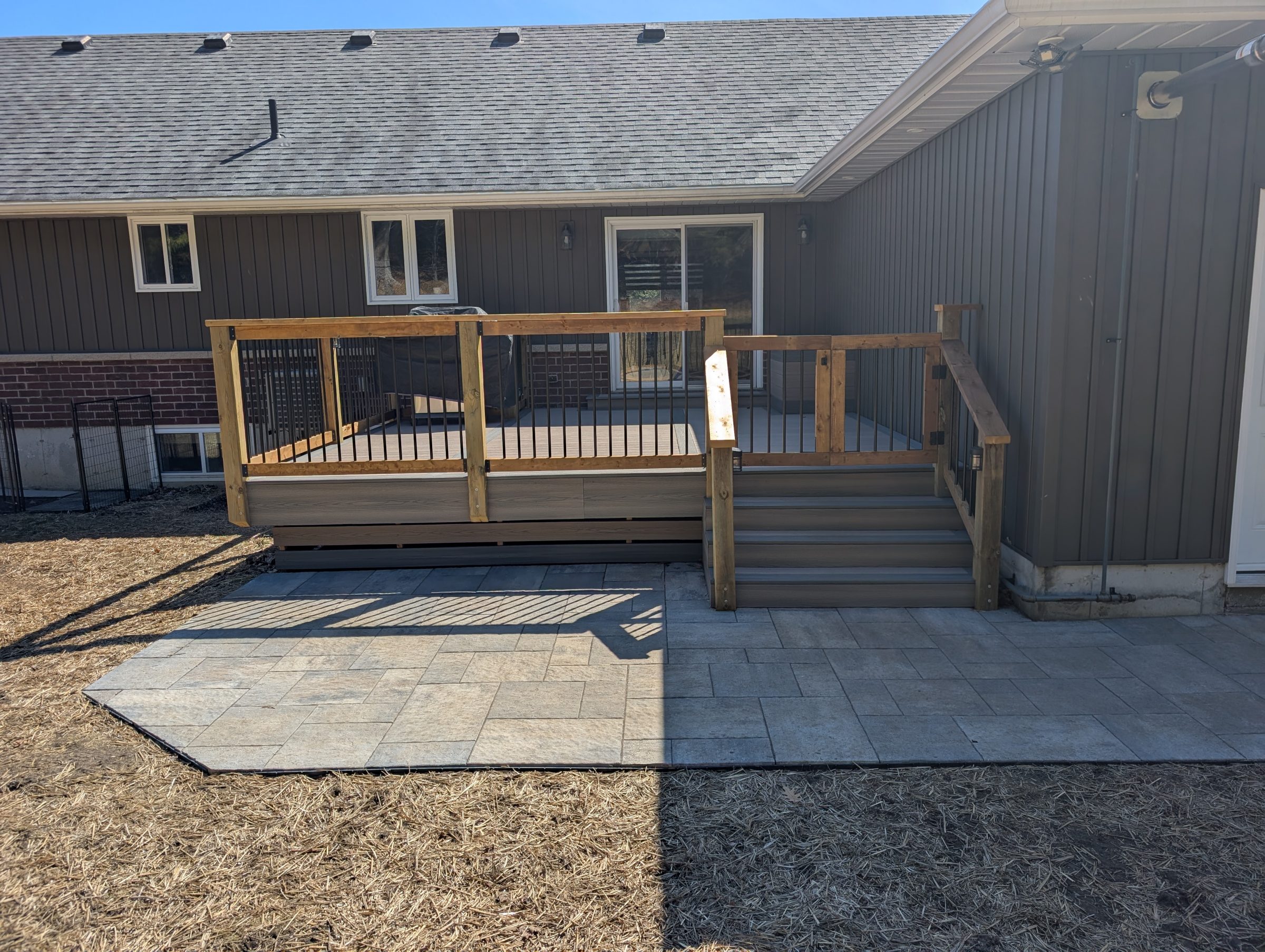 House with wood deck and stone patio