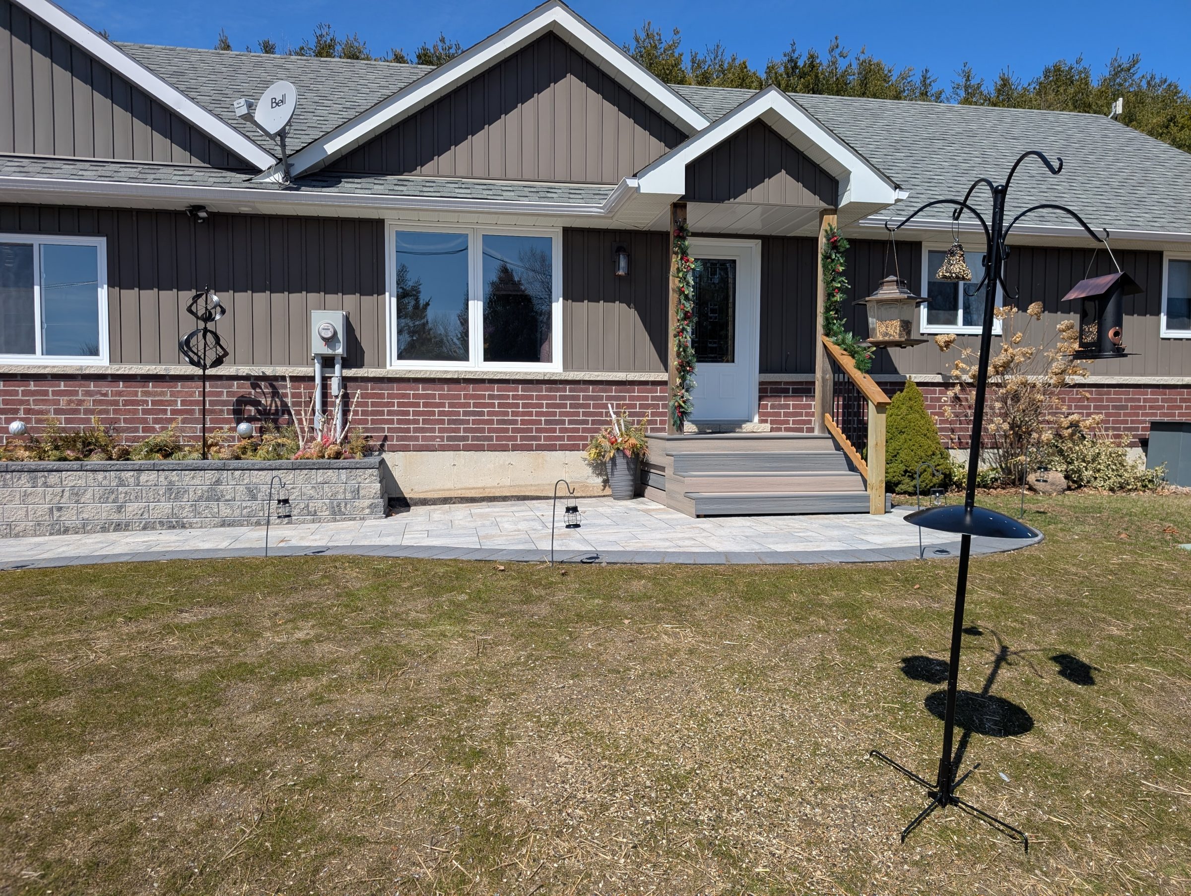 Suburban house with bird feeders on lawn.