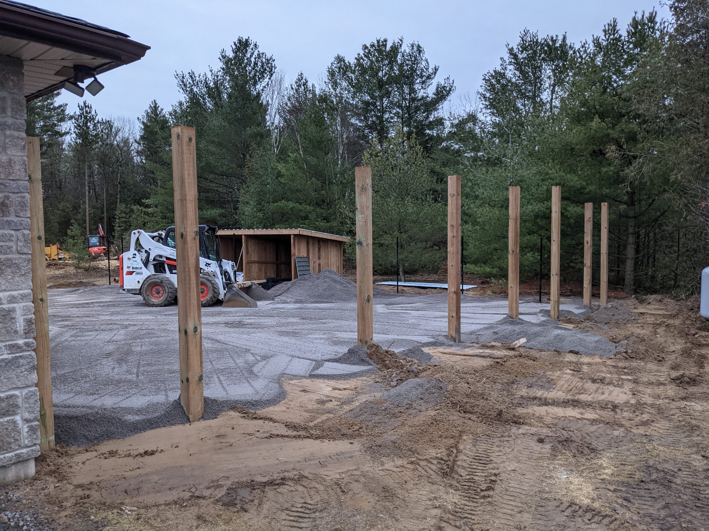 Construction site with wooden posts and machinery.