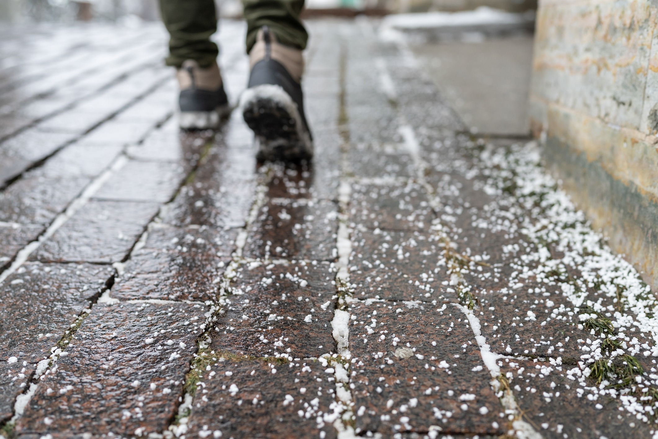 Icy sidewalk with person walking in boots
